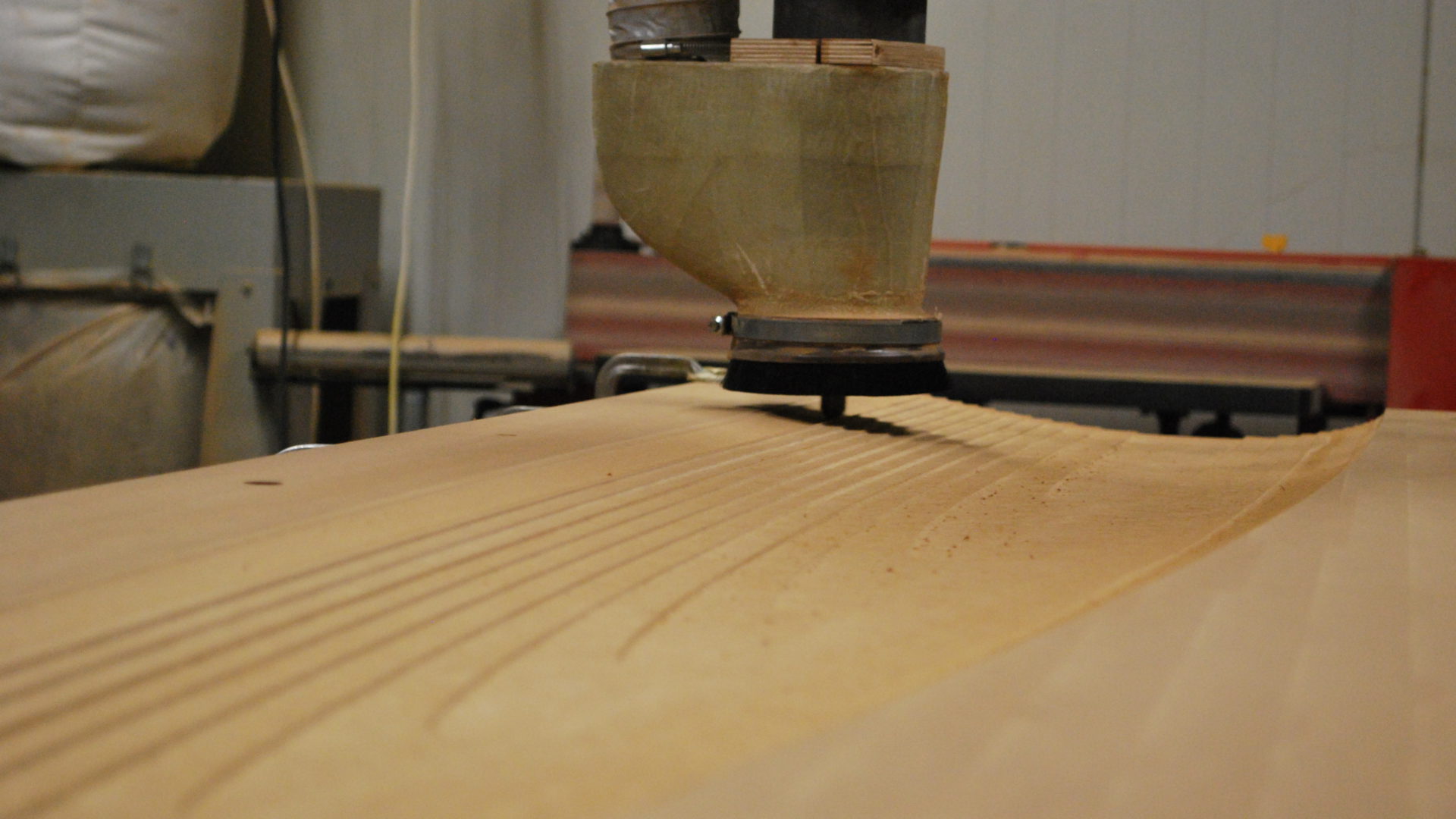 Detailansicht des KUKA KR 210 Roboter beim Fräsen eines Holzmodells.